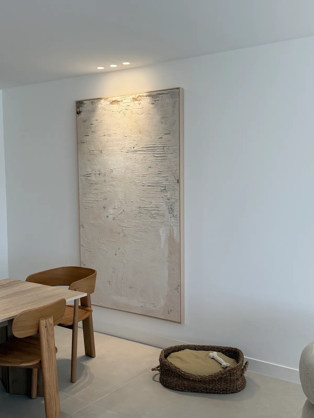 Coin repas devant un panneau de pierre naturelle, appartement rénové à Cannes