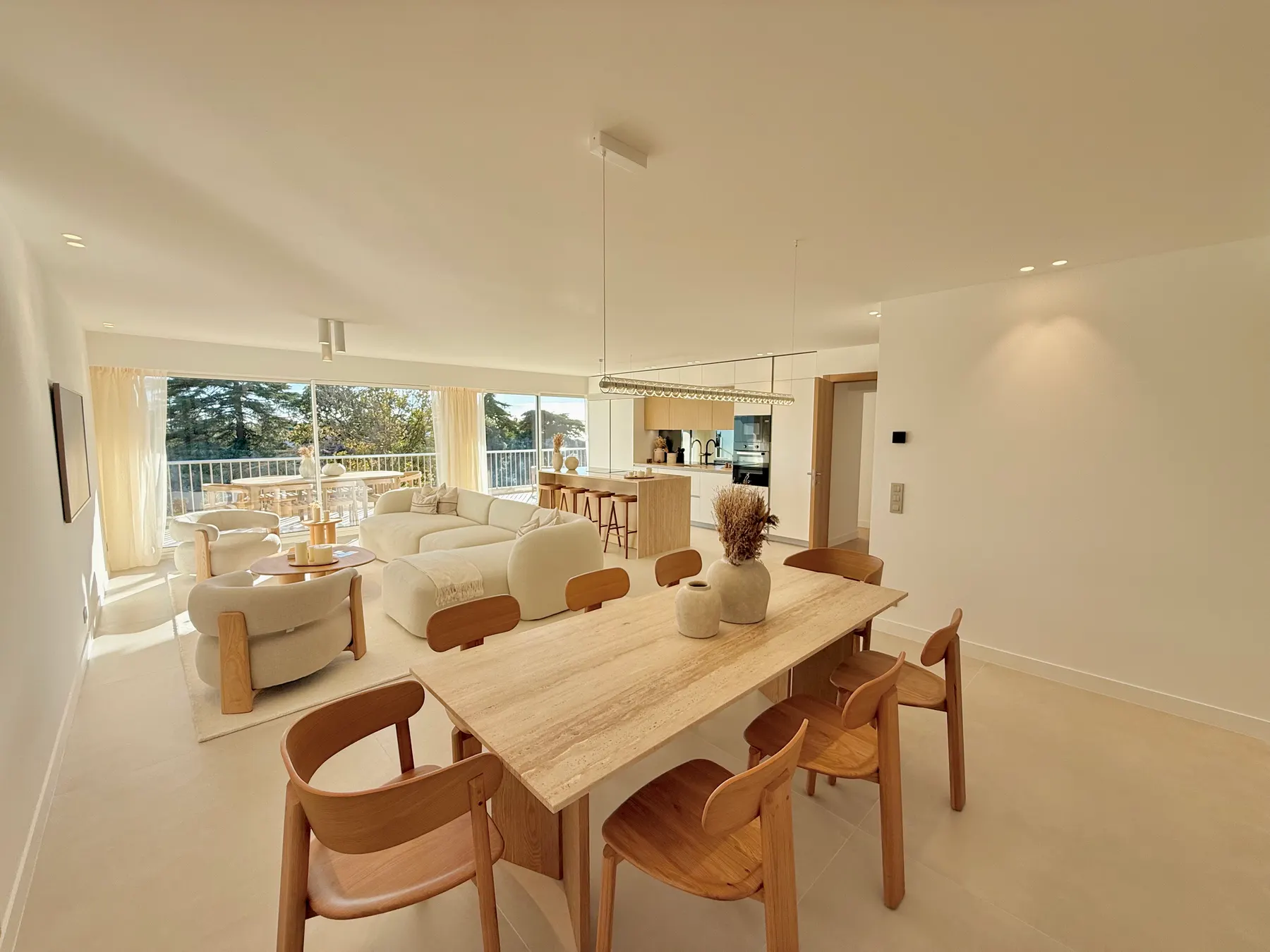 Salle à manger avec table en bois et suspension, appartement rénové à Cannes