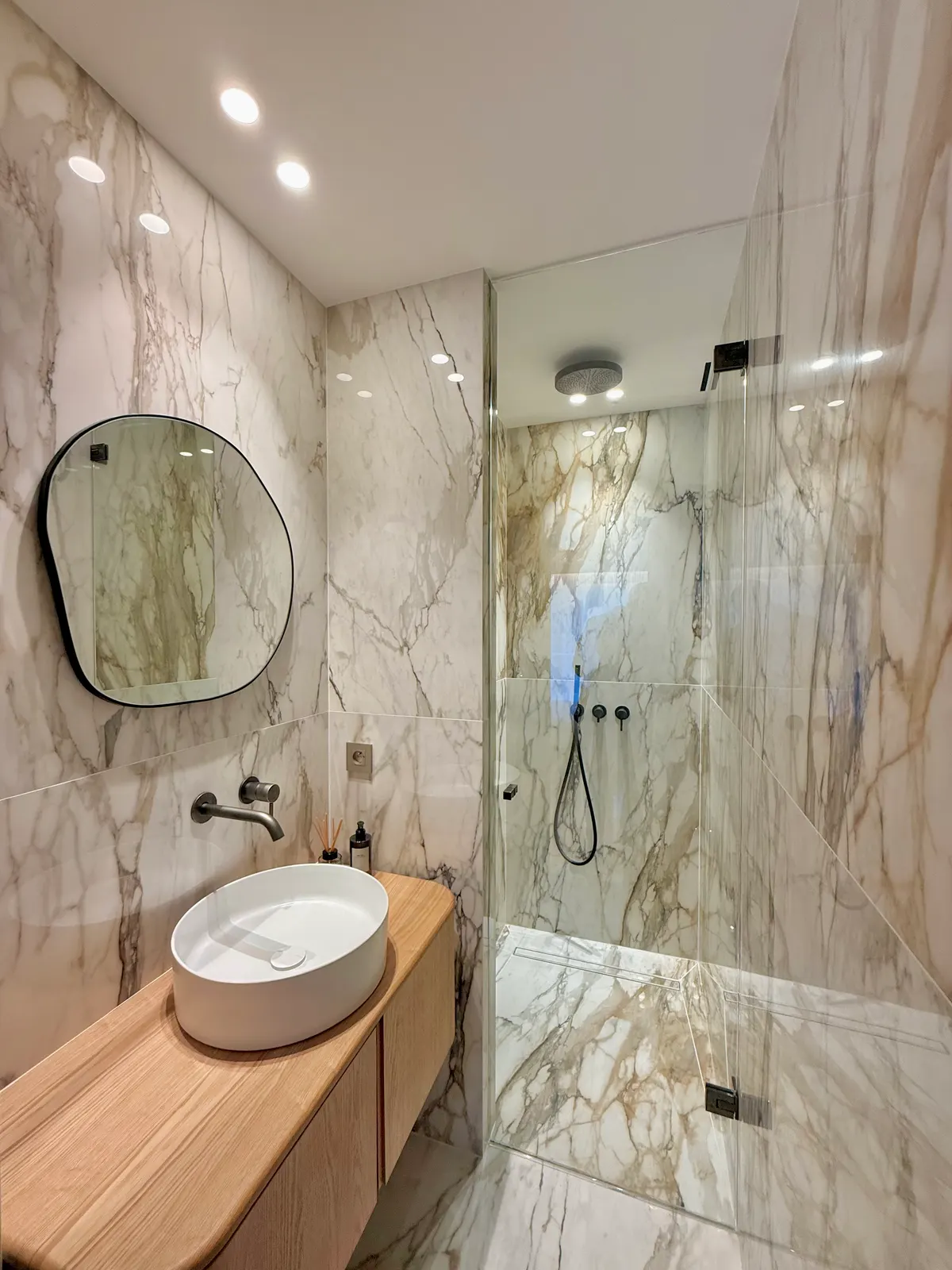 Salle de bains en marbre avec vasque sur meuble bois et douche vitrée, Cannes