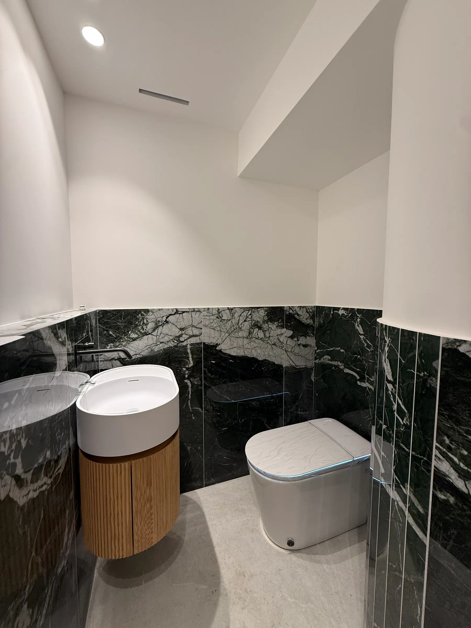 WC habillé de marbre vert avec vasque bois cannelé