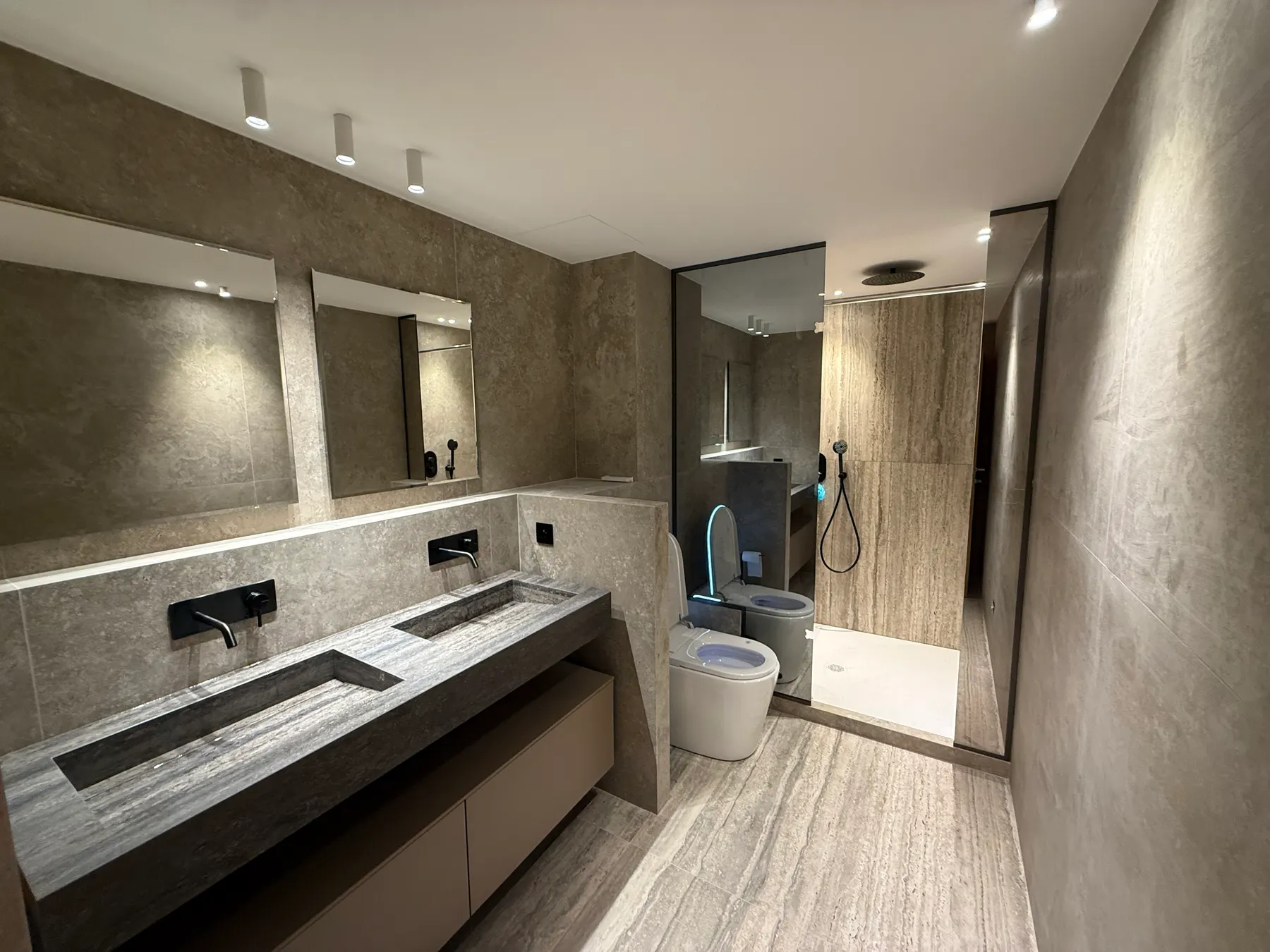 Salle de bains avec plan en pierre et douche à l'italienne