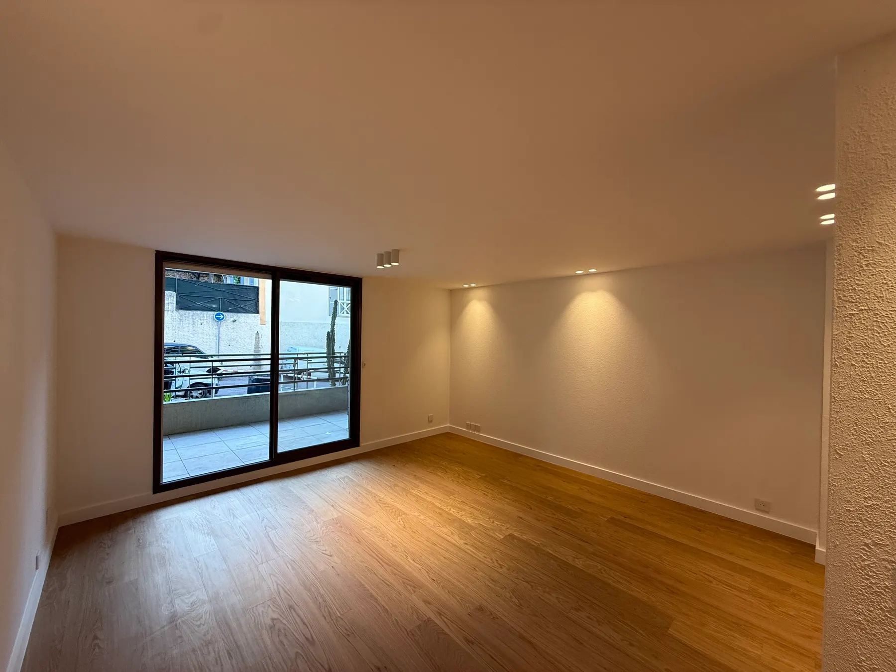 Pièce rénovée avec parquet et baie vitrée sur terrasse, appartement à Nice