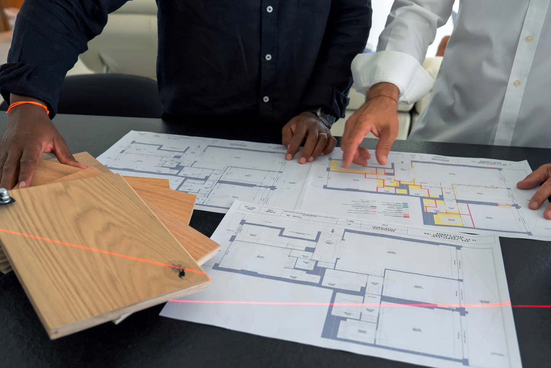 Plans d'appartement et échantillons de parquet chêne sur la table de travail